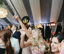 Guests dancing under the tent with cocktails in hand, capturing the high-energy celebration on the packed dance floor.