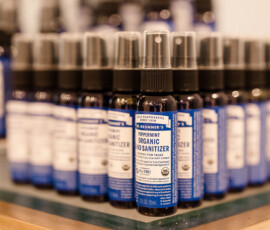 Dr. Bronner’s Peppermint Hand Sanitizer bottles arranged in rows on glass—great for Orange Beach or Gulf Shores weddings.
