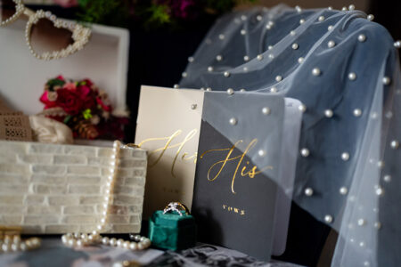 Her Vows and His Vows books with pearls, flowers, and rings create a romantic, elegant wedding scene for timeless inspiration.