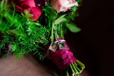 Bouquet with deep pink ribbon and two photo lockets, ideal for romantic New Orleans wedding inspiration.