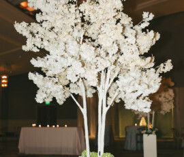 Artificial white-flowered tree in a square planter under glowing lights and curved ceiling—elegant Mobile Alabama wedding decor.
