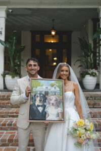 Wedding party portrait on historic home steps with bridesmaids in blush dresses and groomsmen in beige suits.