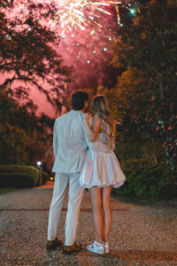 Couple watching colorful fireworks together during a nighttime wedding celebration.