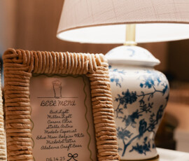 Framed beer menu and floral lamp on ledge create elegant Mobile Alabama wedding vibe; menu lists beers, drink responsibly note.