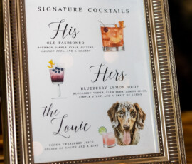 Framed sign shows signature cocktails—His Old Fashioned, Hers Blueberry Lemon Drop, and The Louie with a dog photo.