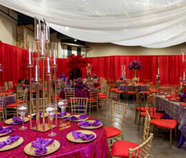 Elegant New Orleans wedding banquet hall with red drapes, gold chairs, purple sequin tables, and magical string lights.