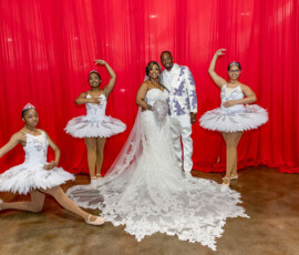 Bride and groom pose before red curtains, with four young ballerinas in white tutus and tiaras for wedding inspiration.