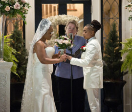 Couple in wedding attire exchange vows and flowers before an officiant, amid floral arrangements at an outdoor Louisiana ceremony.