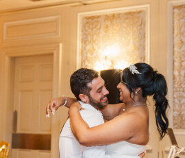 Bride and groom smiling and embracing on the dance floor at their enchanting, warmly lit New Orleans wedding.