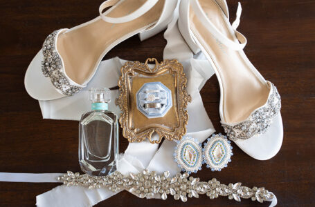 White beaded shoes, jewelry, and perfume are styled with ribbon for classic New Orleans wedding inspiration.