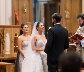 Bride and groom face each other at a Louisiana church altar, with bridesmaid and officiant nearby during the wedding ceremony.