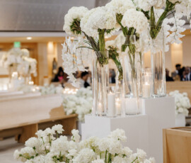 White flowers and candles in tall glass vases create an elegant, classic wedding setting with Louisiana sophistication.