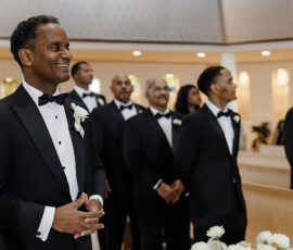 Smiling man in a tuxedo stands with groomsmen at the altar during a New Orleans wedding ceremony.