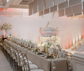 Elegant banquet table with gold cutlery and white flowers in a grand, softly-lit hall—ideal Gulf South wedding inspiration.