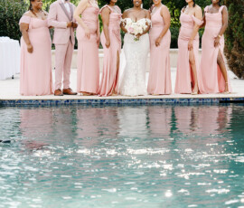 Bride in white with six bridesmaids and a groomsman in blush pink, smiling by a pool at a Gulf South outdoor wedding.