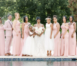 Bride in white gown with bridesmaids, flower girls, and a suited man by a pool at a joyful Louisiana wedding.