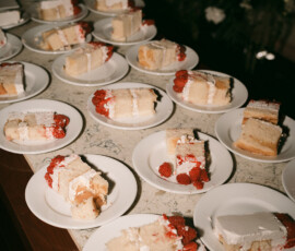 White cake slices with red fruit filling and white frosting on plates atop a marble countertop, ideal for Louisiana weddings.