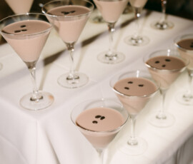 Martini glasses with creamy brown cocktails and coffee bean garnish sit on a white table—ideal for a New Orleans wedding.