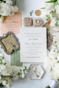 Gulf South wedding invitation suite with jewelry, rings, flowers, and vintage accents on a white background.